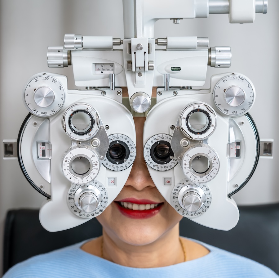 Senior Asian female vision test using phoropter for eye examination and prescription Pre- and post-operative eye surgery co-management in Savannah, TN